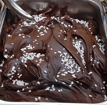 Eisproduktion Milcheis. Schokoladeeis mit dunklem Kakaopulver hergestellt. Schokoladeeis mit sehr dunklem Kakaopulver hergestellt. Schokoladeeis mit Baiserstreusel dekoriert. GroßHandel Eis GmbH