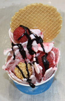 Eis Teppanyaki. Eisbecher mit frischem Himbeer . Joghurt Eis in Röllchenform mit Eiswaffel, Schokotopping und Himbeeren dekoriert bei GroßHandel Eis GmbH